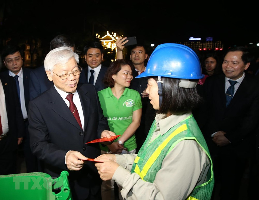 Tổng Bí thư, Chủ tịch nước Nguyễn Phú Trọng mừng tuổi công nhân Công ty Vệ sinh môi trường Hà Nội đang làm việc trên đường Thanh Niên.