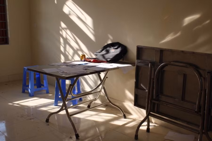 Phòng này còn sót lại bộ bàn ghế với đống giấy tờ nằm la liệt trên bàn.