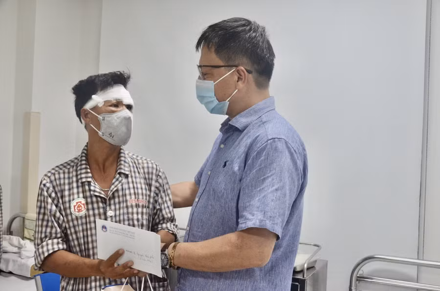 TS. Nguyễn Ngọc Ân, Chủ tịch Công đoàn Giáo dục Việt Nam thăm hỏi, động viên thầy giáo Nguyễn Huy Phú. Ảnh: Ngô Chuyên.