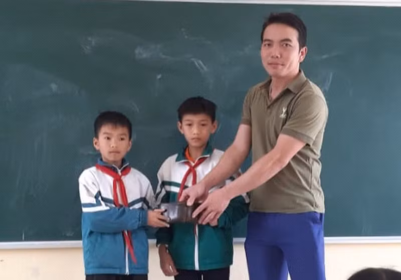 Em Hoàng Nhật Nguyên và Bùi Xuân Thịnh trao trả ví tiền cho người đánh rơi