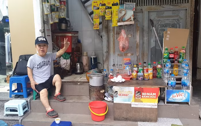 Ông Phú vui vẻ bên quán trà đá mà ông đặt tên là “Đi khắp muôn nơi”.