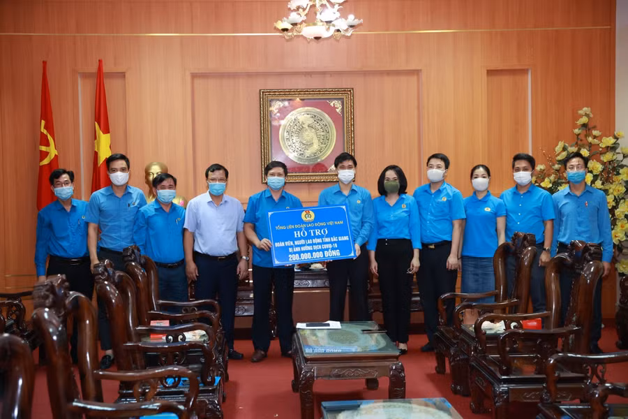 Đại diện Tổng LĐLĐ Việt Nam trao tiền hỗ trợ đoàn viên, người lao động tỉnh Bắc Giang bị ảnh hưởng do dịch Covid-19.
