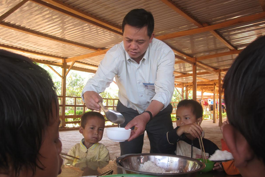 Thầy hiệu trường đến từng bàn lo bữa ăn cho các em.