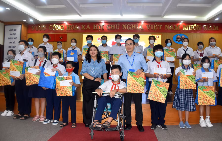 Ban tổ chức trao học bổng “Cùng em vượt khó đến trường” cho các em học sinh.