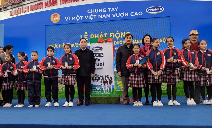 Đại diện Sở GD&ĐT Hà Nội, Vinamilk và giáo viên trao sữa cho các em học sinh trường Tiểu học Kim Đồng