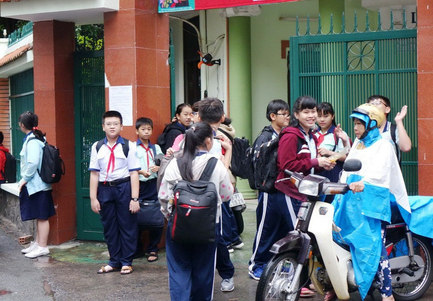 Học sinh Trường THCS Kiến Thiết, Q.3, TPHCM đang chờ phụ huynh đón về tránh bão sáng 25/12. Ảnh: Như Hùng - Báo Tuổi Trẻ