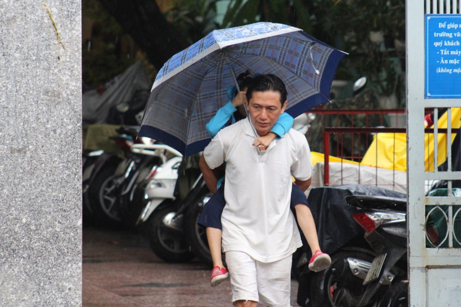 Anh Trần Trọng Nghĩa, ngụ tại Q.10 cõng con về tránh bão sau khi nhận được thông báo của giáo viên chủ nhiệm