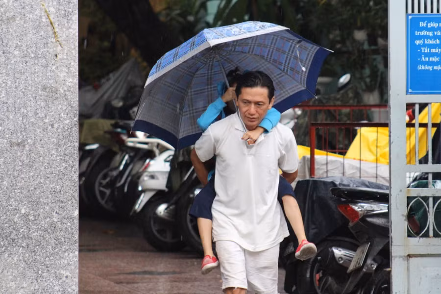 Anh Trần Trọng Nghĩa, ngụ tại Q.10 cõng con về tránh bão sau khi nhận được thông báo của giáo viên chủ nhiệm