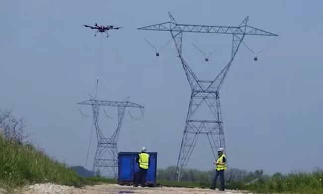 Thiết bị bay giúp con người chăng dây điện 