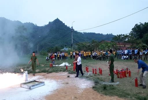 Các thầy cô giáo và học sinh thực hành kỹ năng dùng bình xịt chống cháy