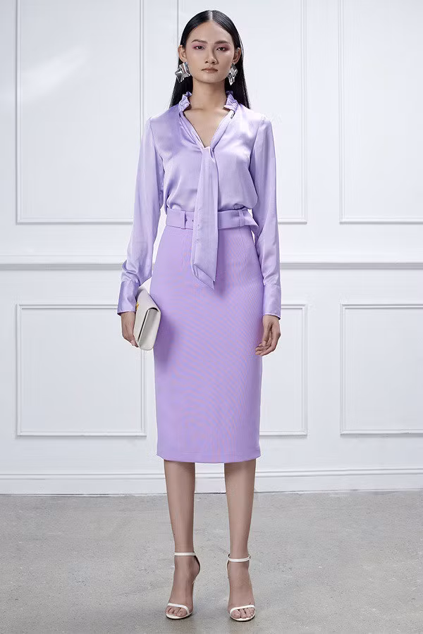 Khi muốn trông nổi bật và phá cách hơn một chút, chị em văn phòng có thể chọn cho mình một outfit với áo blouse lụa và chân váy midi cùng màu tím.