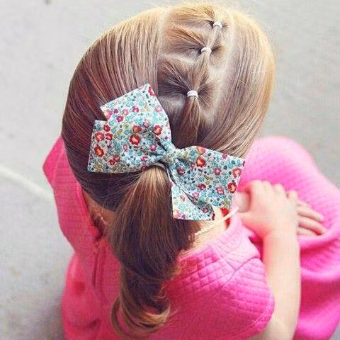 Thắt bím từng đoạn nhỏ từ trái sang phải sau đó cột tóc lệch về 1 bên cho bé thêm phần đáng yêu.