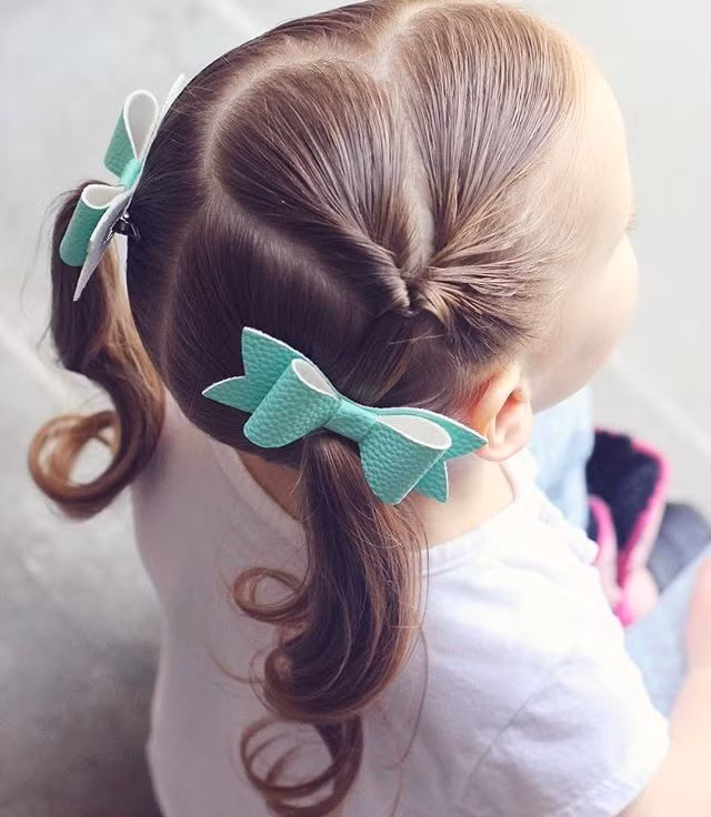 Một bên cột tóc như bình thường, bên còn lại cách điệu bằng cách buộc một phần tóc và lộn ngược vào trong. Buộc tất cả với số tóc còn lại là xong.