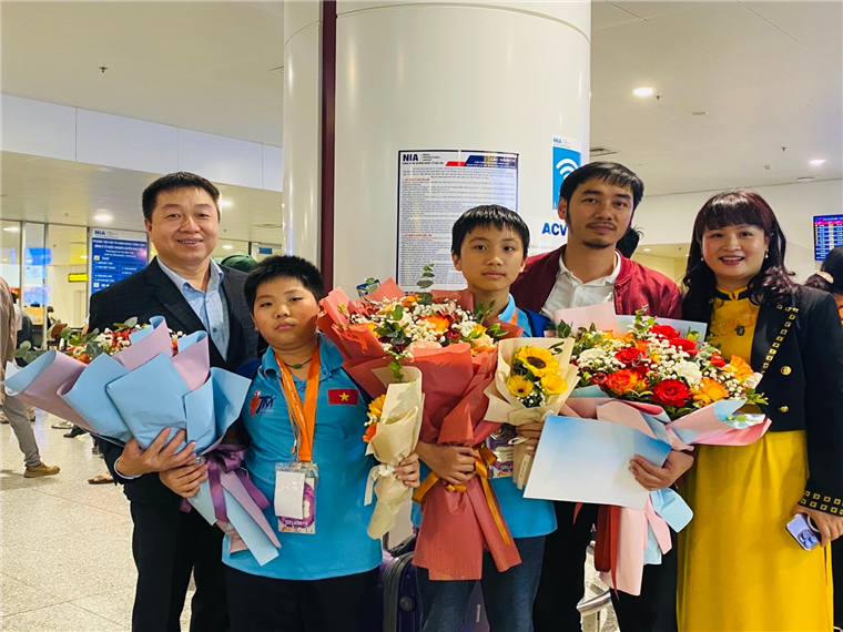 Em Trịnh Lê Hưng (thứ 3 từ trái sang) được thầy giáo chủ nhiệm và các bác phụ huynh đón tại sân bay Nội Bài sau cuộc thi Toán ITMC tại Thái Lan. Em Trịnh Lê Hưng (thứ 3 từ trái sang) được thầy giáo chủ nhiệm và các bác phụ huynh đón tại sân bay Nội Bài sau cuộc thi Toán ITMC tại Thái Lan.