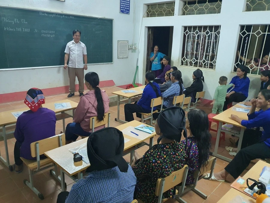 Thầy Nguyễn Văn Quỳnh - Hiệu trưởng Trường Phổ thông DTBT Tiểu học Tân Tiến cùng trao đổi với học viên lớp xoá mù chữ. Ảnh NVCC.