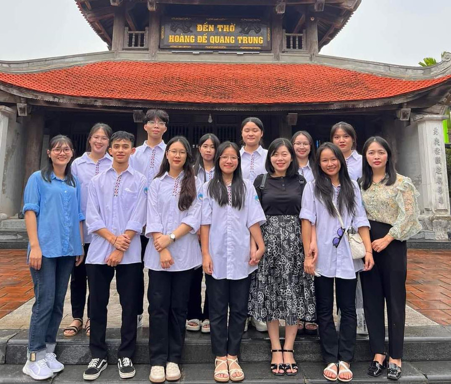 Quỳnh Như (hàng thứ 2, đứng thứ 3 từ trái sang) cùng cô giáo đến thắp hương tại đền thờ Hoàng đế Quang Trung trước ngày đi thi. Ảnh NTCC.