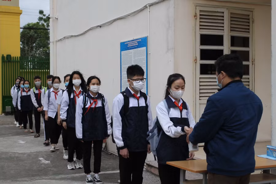 Học sinh được khử khuẩn tay, đo thân nhiệt trước khi vào lớp
