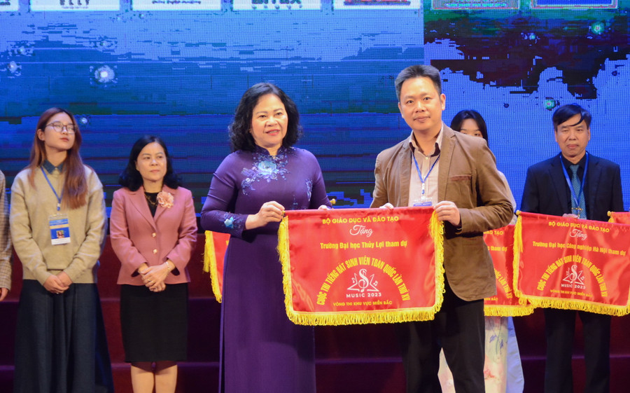 Thứ trưởng Ngô Thị Minh trao cờ cho các đơn vị tham dự cuộc thi.