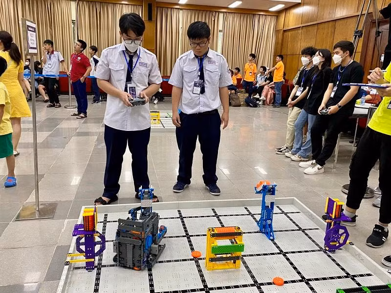 Nghiệp Quý (bên phải), Minh Khang (bên trái) đang điều kiển robot của mình tại National Robotics Tournament 2022. Ảnh NC.