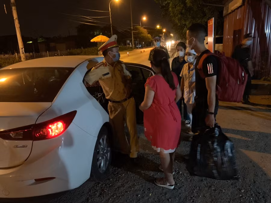 Cán bộ chốt Covid-19 giúp đỡ sản phụ đến bệnh viện an toàn.