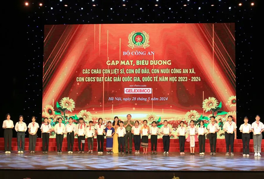 Thứ trưởng điều hành Bộ Công an Trần Quốc Tỏ và Phó Chủ tịch Hội Liên hiệp Phụ nữ Việt Nam Tôn Ngọc Hạnh trao thưởng cho các học sinh.