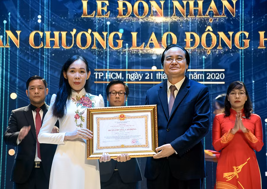 Bộ trưởng Phùng Xuân Nhạ (phải) trao Huân chương Lao động hạng Ba cho PGS.TS Trần Thị Mỹ Diệu - Hiệu trưởng VLU.