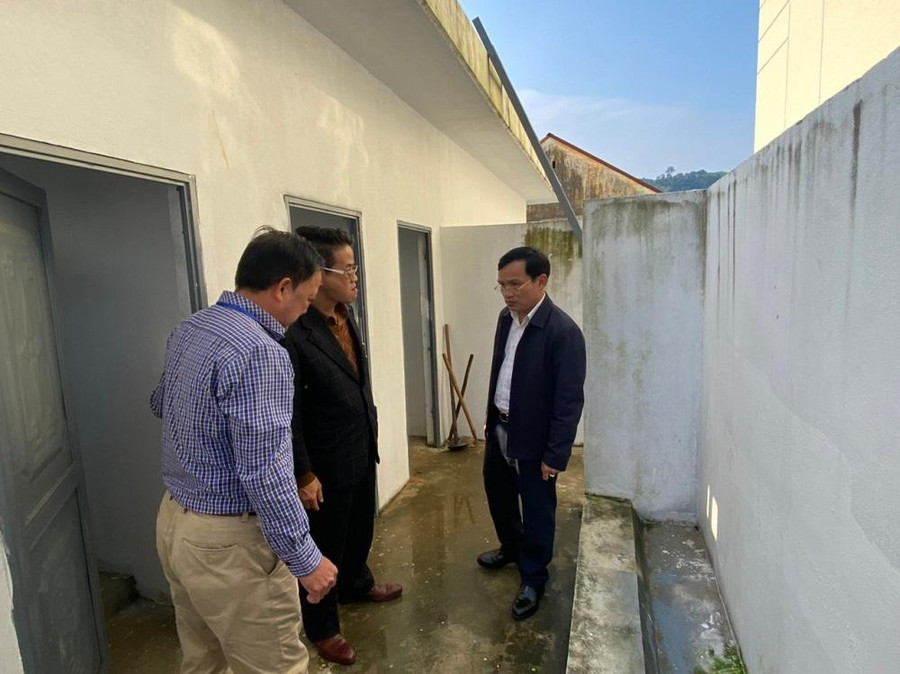 Ông Mai Văn Trinh kiểm tra hệ thống nhà vệ sinh tại Trường TH &amp; THCS Đồng Tâm. Ảnh Ngô Chuyên.