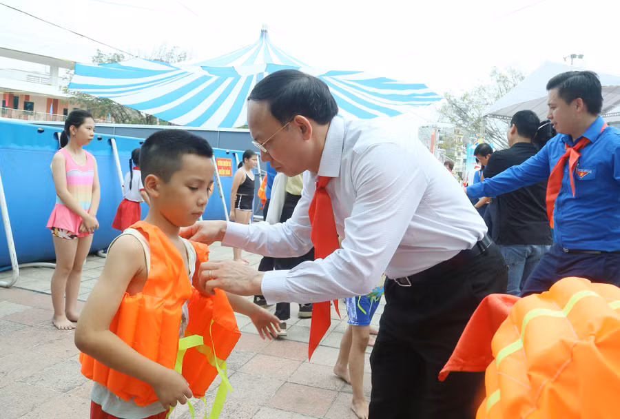 Ông Nguyễn Xuân Ký, Bí thư Tỉnh ủy Quảng Ninh trao áo phao cho các em thiếu nhi học lớp bơi miễn phí.