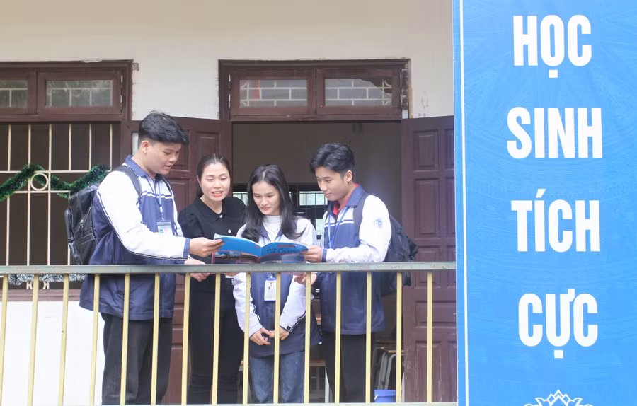 Cô Ðinh Thị Hồng Như cùng Đỗ Chí Tiến và các bạn học sinh Trường THPT Minh Quang trao đổi sau giờ học.