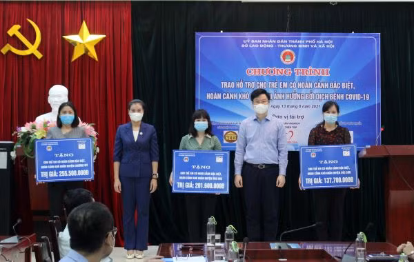 Giám đốc Sở Lao động Thương binh và Xã hội Hà Nội Bạch Liên Hương cùng Giám đốc Quỹ Thiện Tâm Lý Minh Tuấn trao hỗ trợ cho đại diện phòng LĐTB&amp;XH các huyện Ứng Hòa, Sóc Sơn và Chương Mỹ.