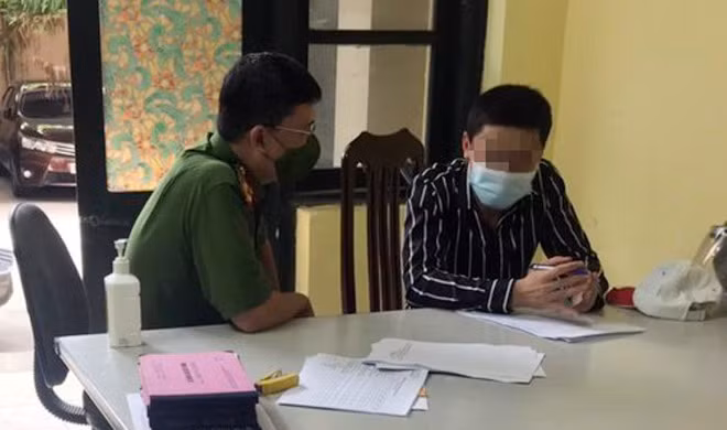 Đối tượng N.N (bên phải) tại cơ quan công an. 