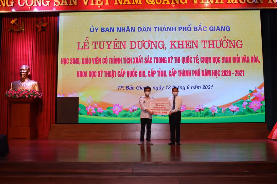 Khen thưởng em Nguyễn Thanh Bình (bên trái) HS lớp 12 chuyên Vật lý, Trường THPT Chuyên Bắc Giang vừa đoạt Huy chương Đồng (HCĐ) Olympic Vật lý châu Âu.