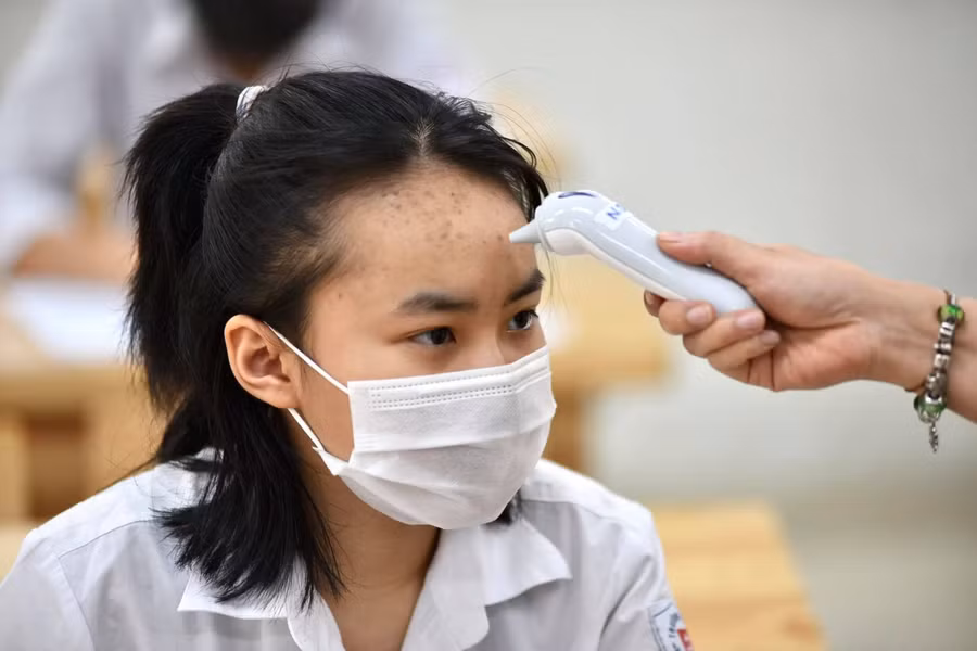Đo thân nhiệt cho thí sinh.