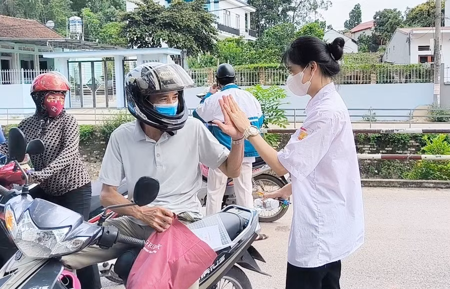 Phụ huynh đưa thí sinh đến điểm thi và động viên bằng cách đánh tay.