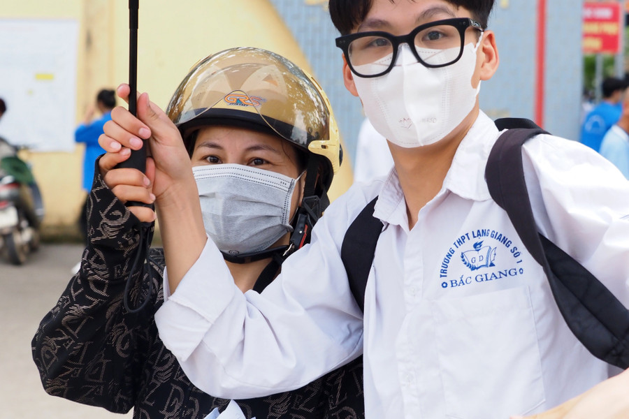 Mẹ che ô động viên con trai trong kỳ thi. Mẹ che ô động viên con trai trong kỳ thi.