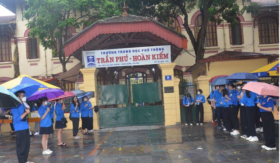 Sinh viên tình nguyện đội mưa chờ thí sinh. Ảnh Phạm Hiền. Sinh viên tình nguyện đội mưa chờ thí sinh. Ảnh Phạm Hiền.