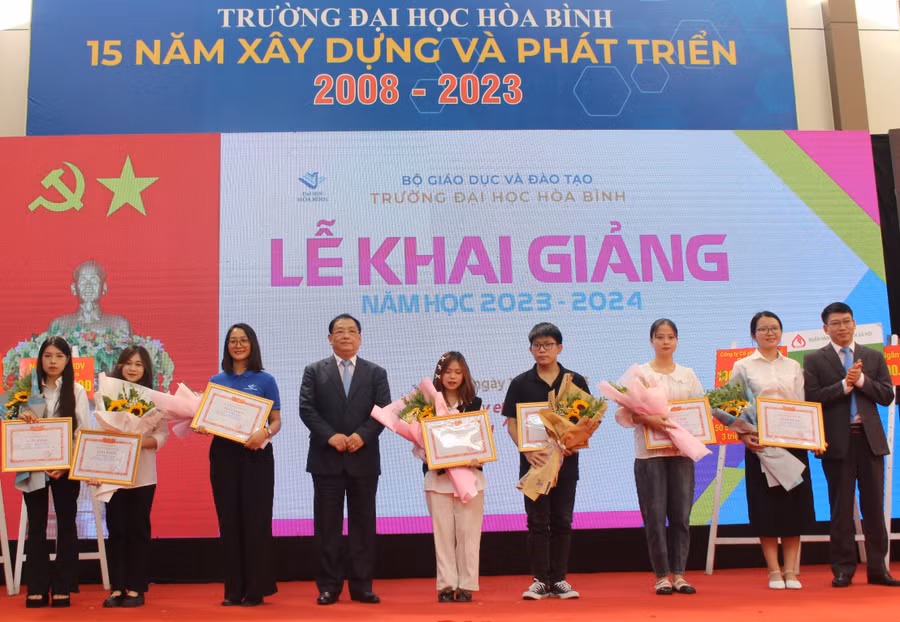 NGND PGS.TS Tô Ngọc Hưng - Hiệu trưởng Trường Đại học Hòa Bình (thứ 4 từ trái sang phải) khen thưởng sinh viên có thành tích năm học 2022 -2023.