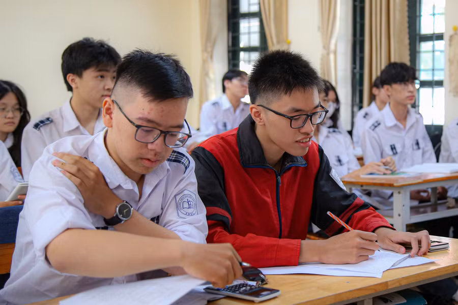 Thân Thế Công (áo đỏ) trong giờ học.