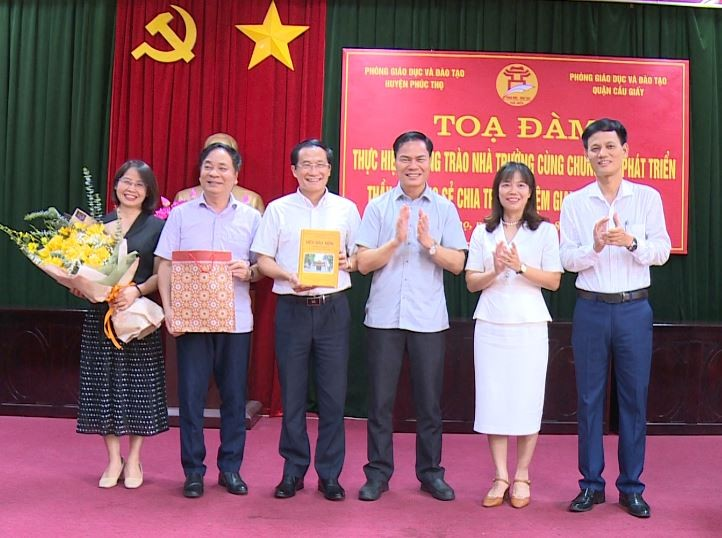 Lãnh đạo hai Phòng GD&ĐT trao quà kỉ niệm.