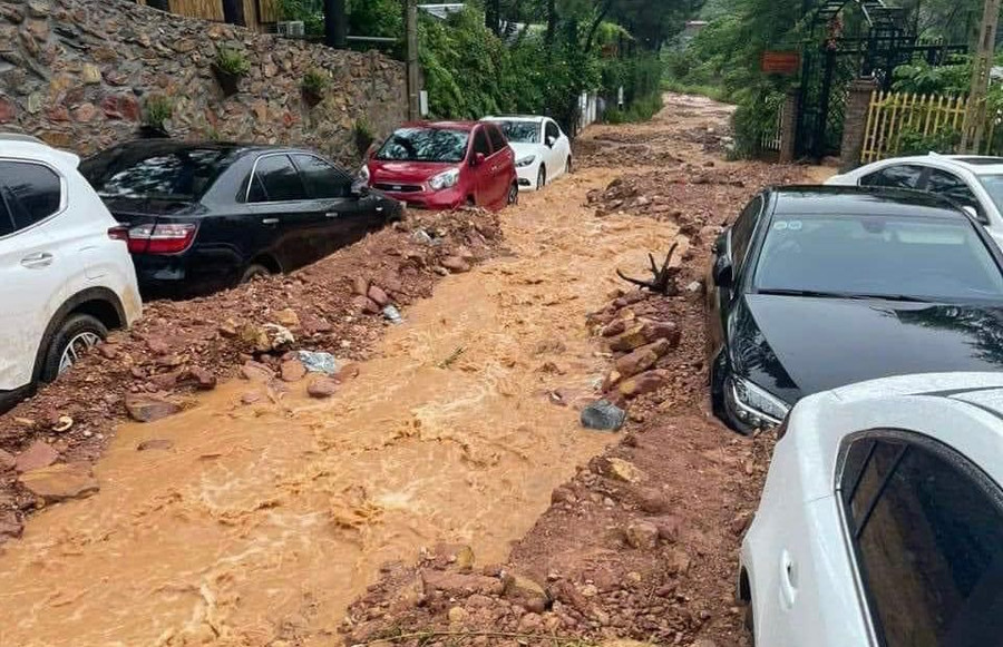 Hình ảnh ô tô chưa thể di chuyển do bị nước lũ, đất đá bao quanh.