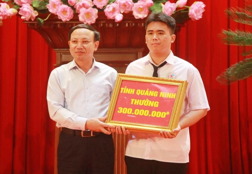 Ông Nguyễn Xuân Ký, Bí thư Tỉnh ủy Quảng Ninh trao Bằng khen và tiền thưởng 300 triệu đồng cho em Vũ Huy Hoàng, học sinh lớp 12 tin, Trường THPT Chuyên Hạ Long đoạt Huy chương Bạc Olympic Tin học Châu Á – Thái Bình Dương.