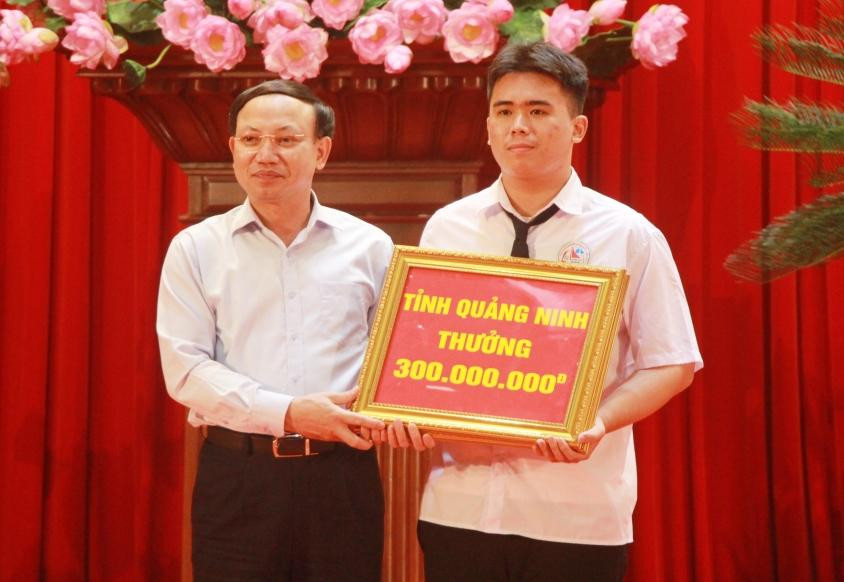 Ông Nguyễn Xuân Ký, Bí thư Tỉnh ủy Quảng Ninh trao Bằng khen và tiền thưởng 300 triệu đồng cho em Vũ Huy Hoàng, học sinh lớp 12 tin, Trường THPT Chuyên Hạ Long đoạt Huy chương Bạc Olympic Tin học Châu Á – Thái Bình Dương.