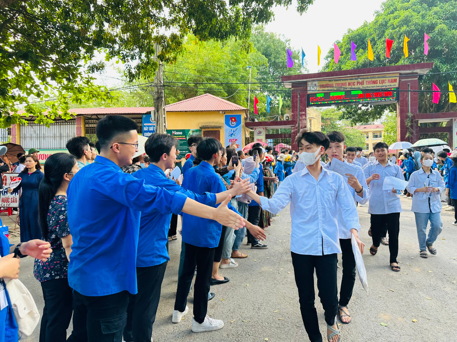 Thí sinh rời trường thi trong không khí vui tươi và phấn khởi động viên của thanh niên tình nguyện.