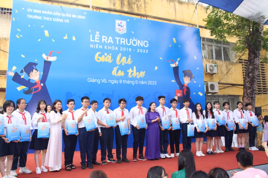 Ban giám hiệu tặng quà cho học sinh khối 9 trong lễ ra trường.