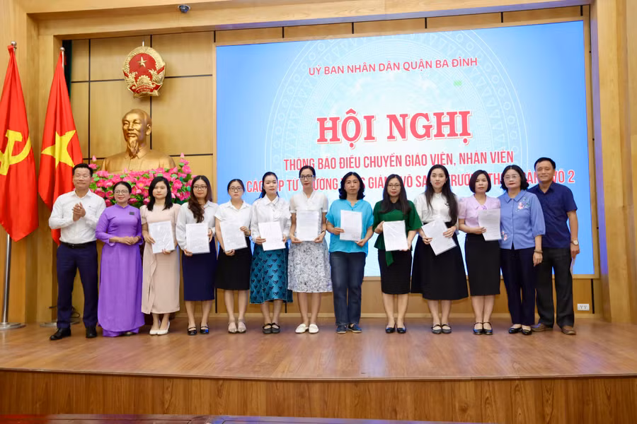 TS. Lê Đức Thuận (áo trắng) và ông Nguyễn Mạnh Cường cùng đại diện hai trường THCS (Giảng Võ, Giảng Võ 2) trao quyết định và chụp ảnh lưu niệm với giáo viên được điều chuyển.