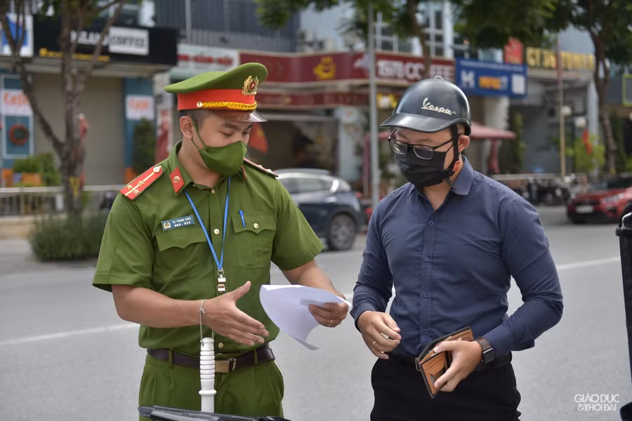 Lực lượng chức năng tuyên truyền nhắc nhở người dân thực hiện nghiêm quy định phòng dịch (Ảnh Thế Đại).