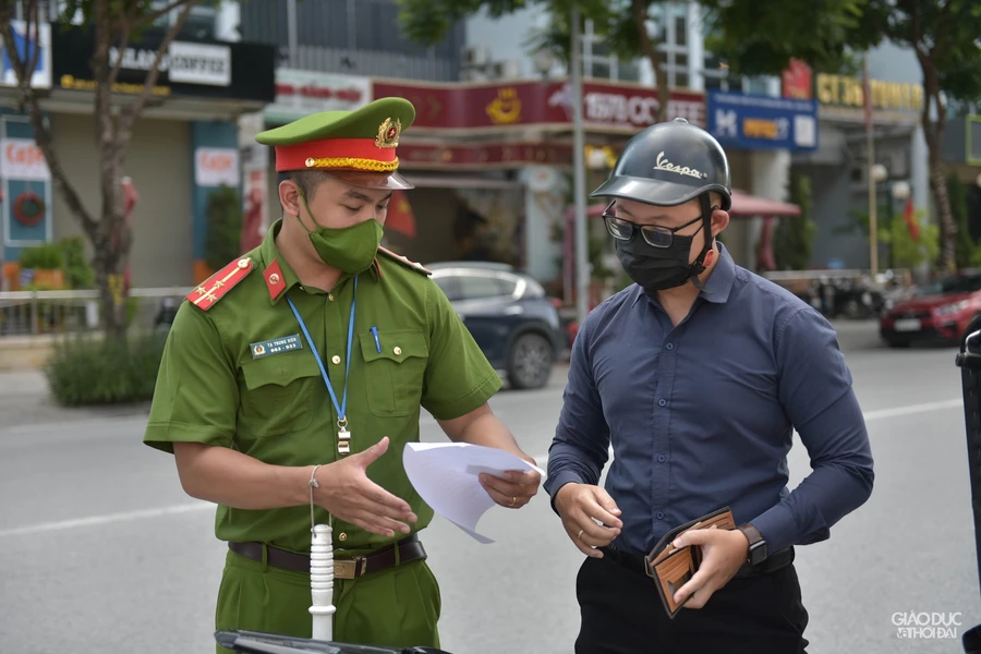 Lực lượng chức năng tuyên truyền nhắc nhở người dân thực hiện nghiêm quy định phòng dịch (Ảnh Thế Đại).