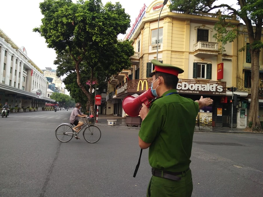 Công an quận Hoàn Kiếm tuyên truyền, nhắc nhở người dân không ra khỏi nhà khi không cần thiết.