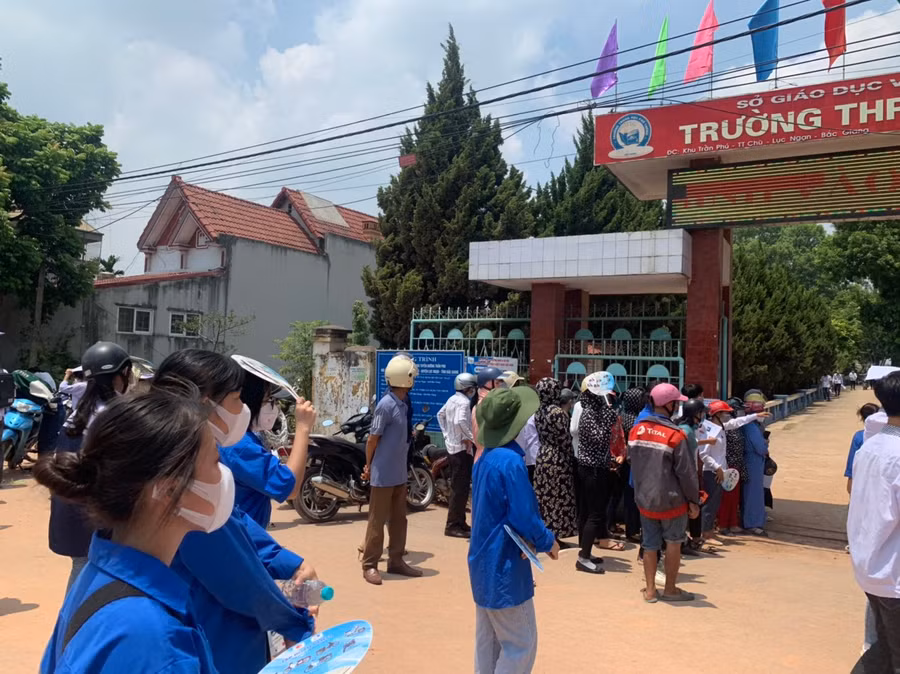 Lực lượng tình nguyện "đội nắng" động viên thí sinh trong ngày thi đầu tiên.