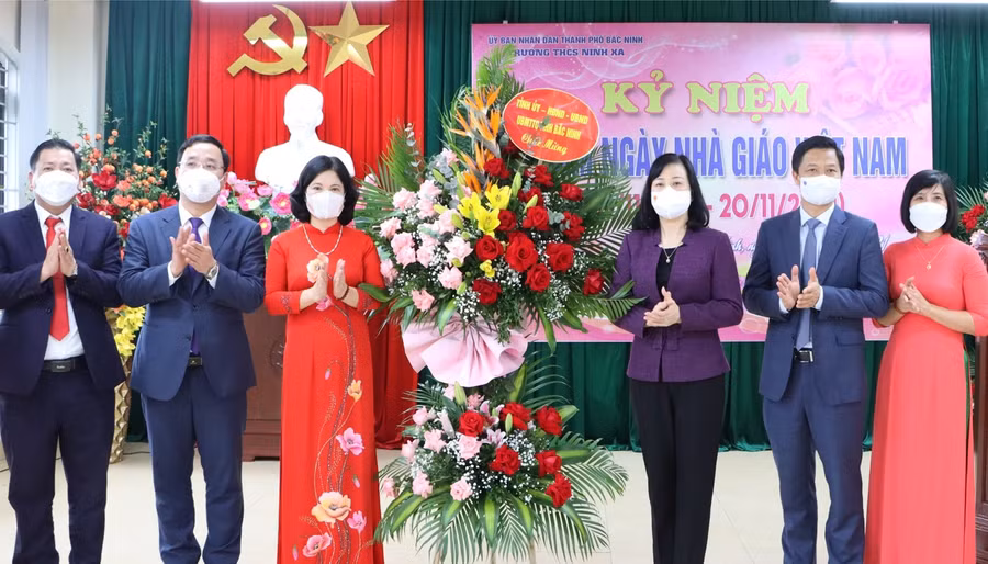 Bí thư Đào Hồng Lan tặng hoa chúc mừng thầy, cô Trường THCS Ninh Xá.